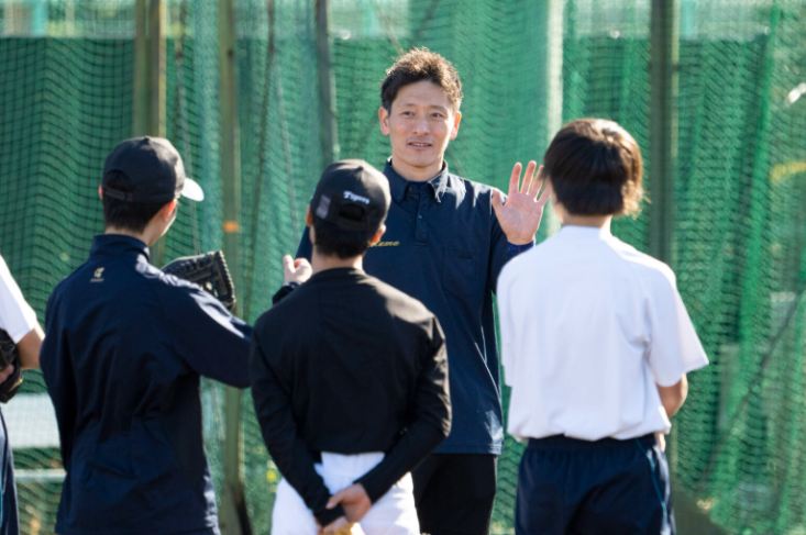 野球の指導の場で中学生と話す講師の米田